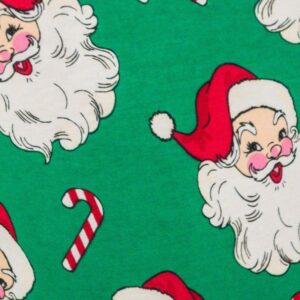 Santa faces and candy canes on green background
