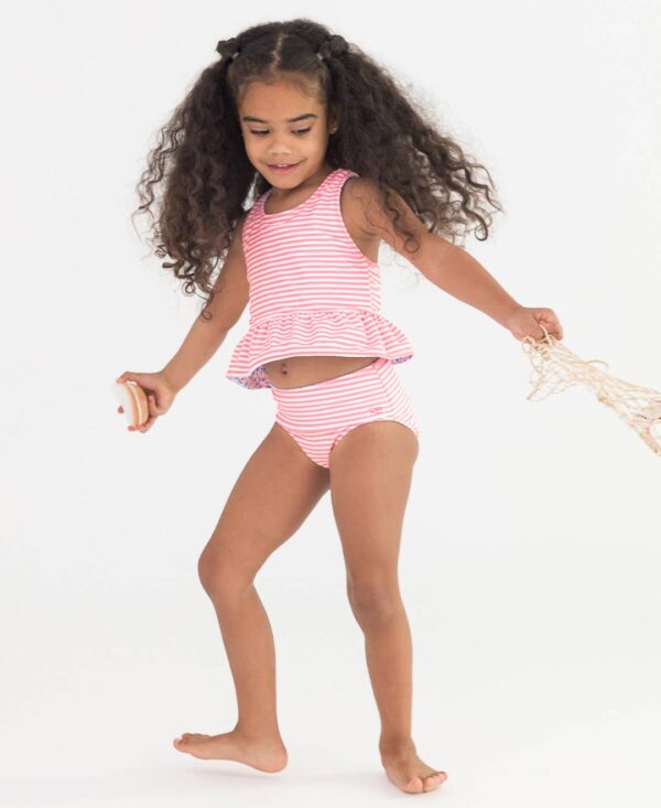 rufflebutts cottage tea time reversible peplum tankini Child in striped swimsuit holding net.
