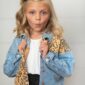 Child in denim leopard jacket making funny face.