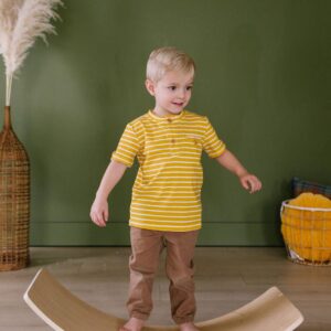 Child balancing on wooden board indoors