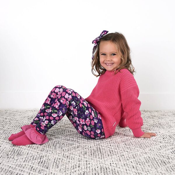 gigi and max mila leggings and sweater set Smiling child in pink sweater and floral leggings.