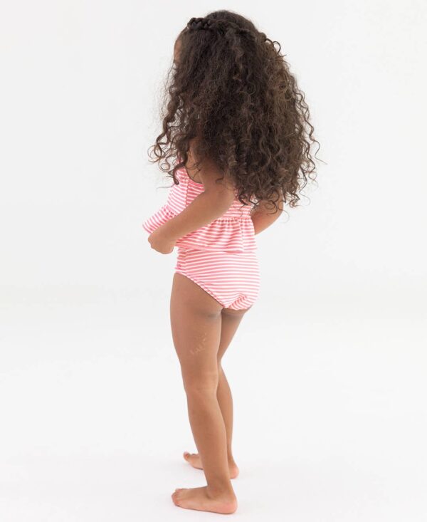 rufflebutts cottage tea time reversible peplum tankini Child wearing striped swimsuit standing