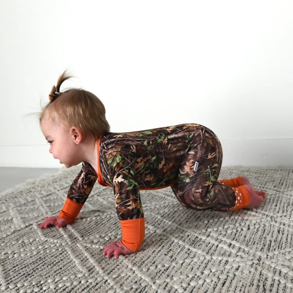 gigi and max hunter camo zip sleepies little bamboo baby outfit Baby crawling in camo outfit with orange accents.
