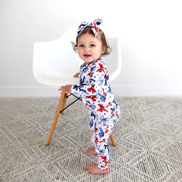 gigi and max eleanor bow clip bow 4th of july hair accessory Baby in patterned outfit and headband near chair