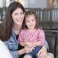 Smiling woman and child indoors portrait.