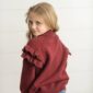 Girl in red sweater with ruffled sleeves.