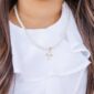 Pearl necklace with gold cross pendant.