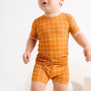 Toddler in orange grid-patterned outfit