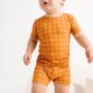 Toddler in orange grid-patterned outfit