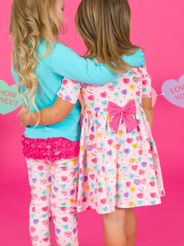 rufflebutts + ruggedbutts girls be my valentine short sleeve knit twirl dress Two kids hugging in heart-patterned clothes.