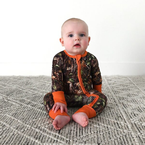 gigi and max hunter camo zip sleepies little bamboo baby outfit Baby wearing camouflage pajamas sitting on carpet