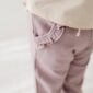 Child wearing pants with ruffled pocket detail.