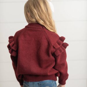 Girl in maroon sweater with ruffled sleeves
