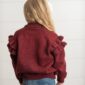Girl in maroon sweater with ruffled sleeves