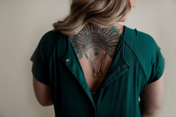 Back tattoo with animal skull and feathers.