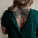Back tattoo with animal skull and feathers.