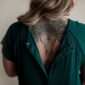 Back tattoo with animal skull and feathers.