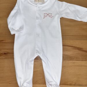 White baby onesie on wooden surface.