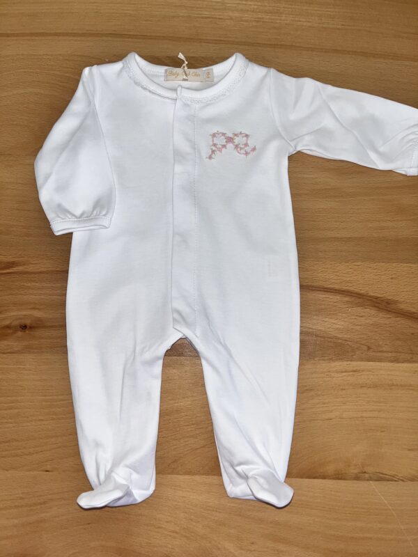 White baby onesie on wooden surface.