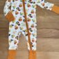 Baby pajamas with duck and pumpkin pattern.