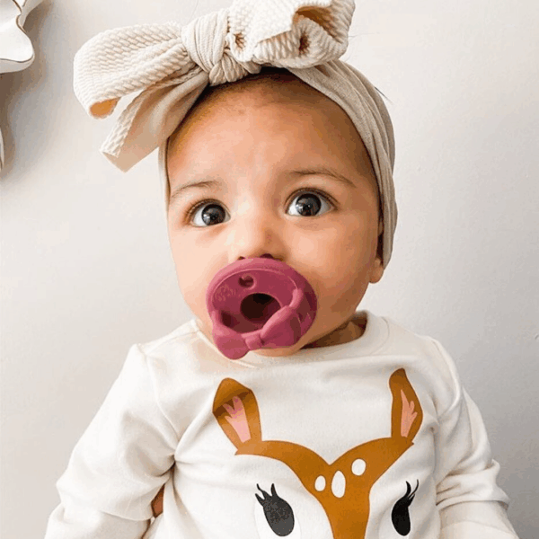 itzy ritzy sweetie soother™ pacifier sets (2 pack): agave + succulent cables Baby with bow and deer shirt, pink pacifier