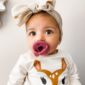 Baby with bow and deer shirt, pink pacifier