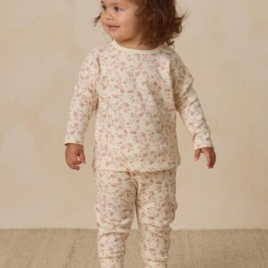 Toddler in floral pajamas standing on carpet