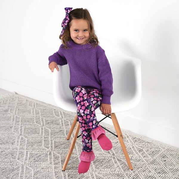 gigi and max mila leggings and sweater set Child in purple sweater and floral leggings, sitting.