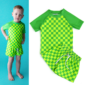 Child wearing green checkered shirt and shorts set.