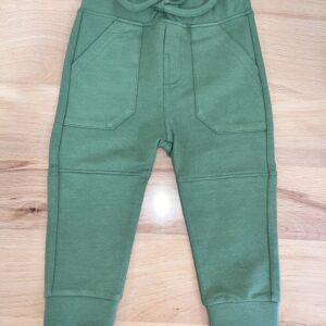 Green toddler leggings on wooden surface