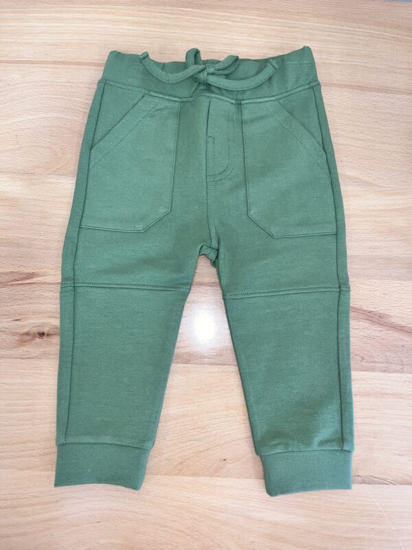 Green toddler leggings on wooden surface