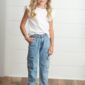 Smiling child in casual outfit on wooden floor.