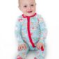 Baby in festive pajamas with holiday designs.