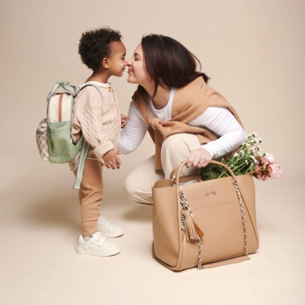 itzy ritzy *new/restocked* chai latte boss tote™ Smiling mother and child with bags and flowers.