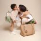 Smiling mother and child with bags and flowers.