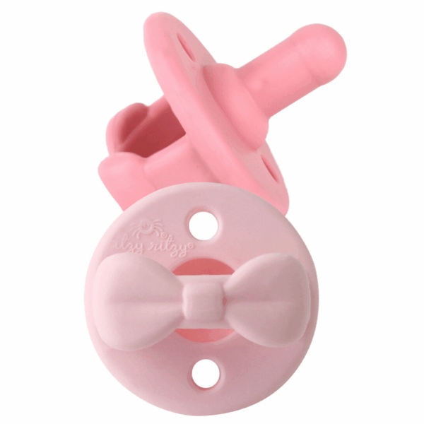 itzy ritzy sweetie soother™ pacifier sets (2 pack): agave + succulent cables Pink baby pacifier with attached bow design.
