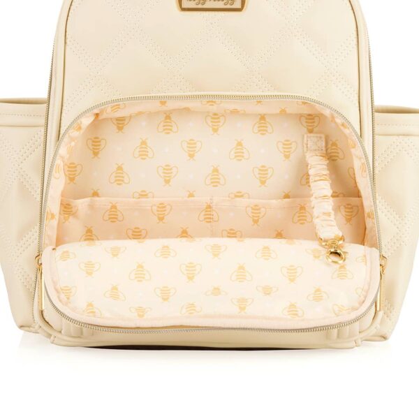 itzy ritzy milk & honey itzy mini plus™ diaper bag backpack Open beige diaper bag with bee print interior.