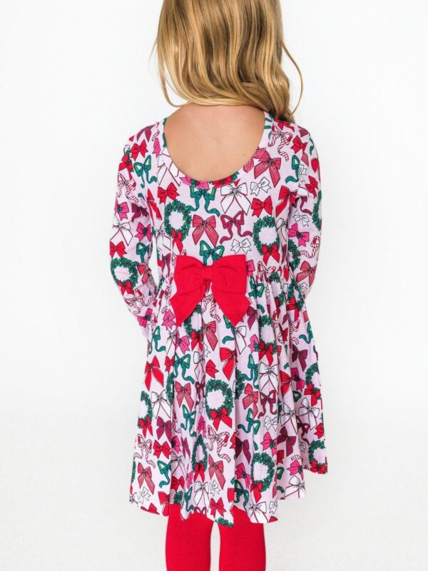 rufflebutts holly bow long sleeve knit twirl dress Girl in festive dress with bow and wreath print