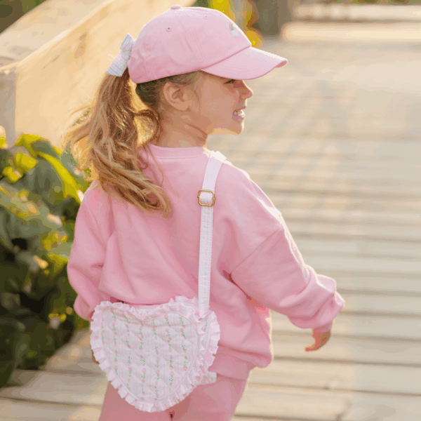 bits & bows floral quilted heart purse Child in pink outfit with heart-shaped bag.