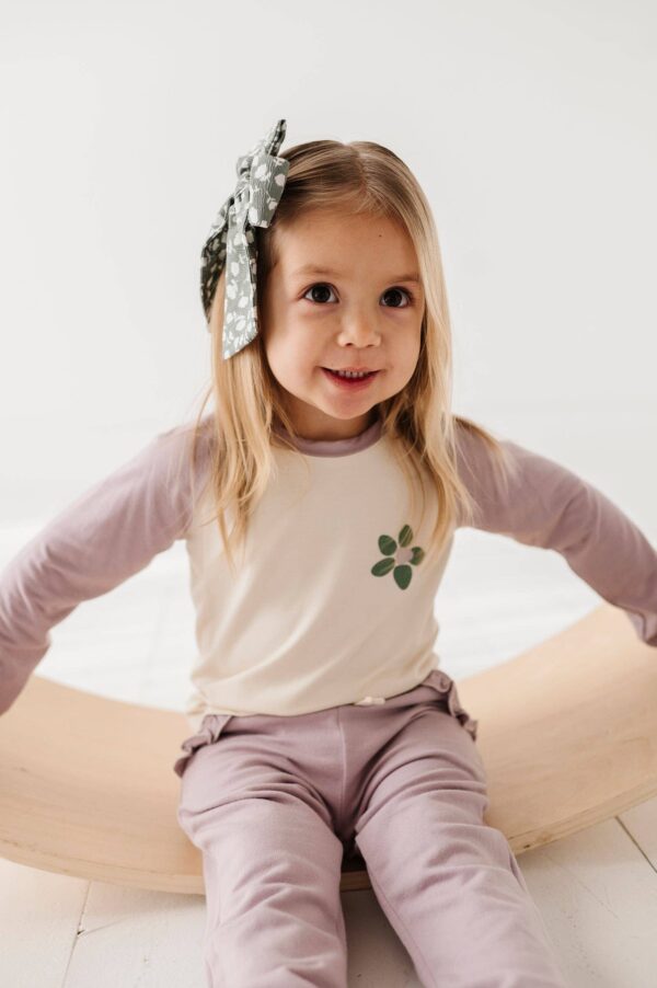 babysprouts clothing company girl's joggers bamboo Child smiling with polka dot bow in hair.