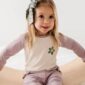 Child smiling with polka dot bow in hair.