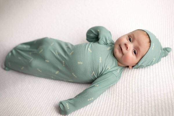three little tots arrow print knotted newborn baby gown pajamas Baby in green outfit lying on bed