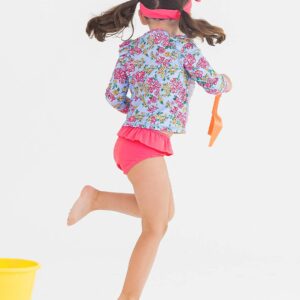 Girl playing in colorful swimsuit with yellow bucket.