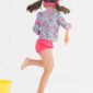 Girl playing in colorful swimsuit with yellow bucket.