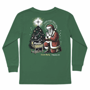 Santa kneeling by nativity and Christmas tree.