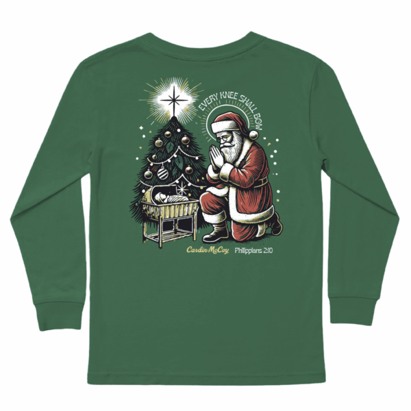 Santa kneeling by nativity and Christmas tree.