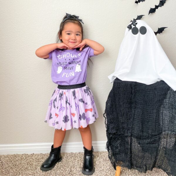 sweet wink spooky bow tutu skirt Child in Halloween costume next to ghost decoration.