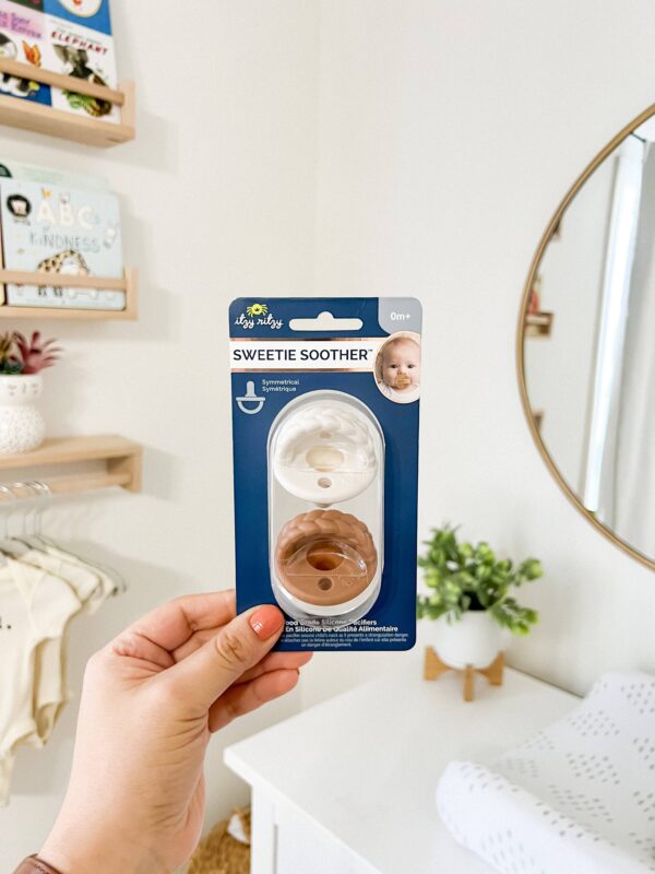 itzy ritzy sweetie soother™ pacifier sets (2 pack): agave + succulent cables Hand holding Itzy Ritzy Sweetie Soother pacifiers
