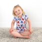 Smiling child in butterfly-patterned outfit.