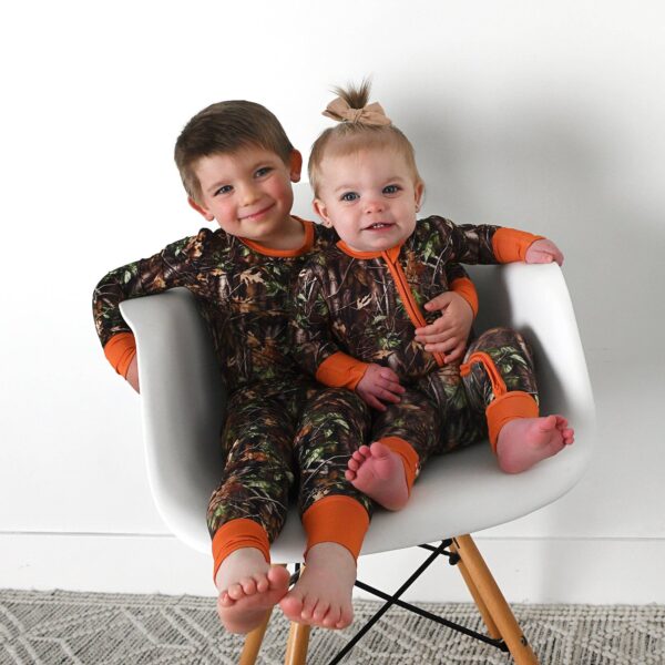 gigi and max hunter camo two piece no button bamboo outfit lounge Two children in camo pajamas sitting together.